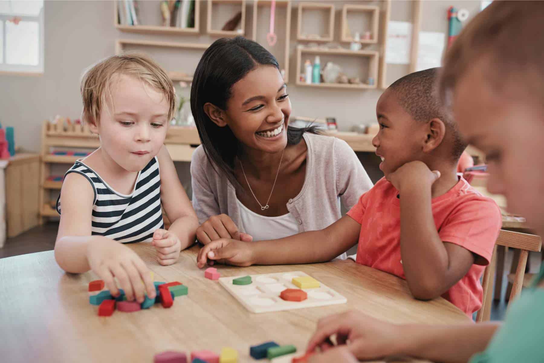 Children playing educational games with a caregiver in a preschool classroom.