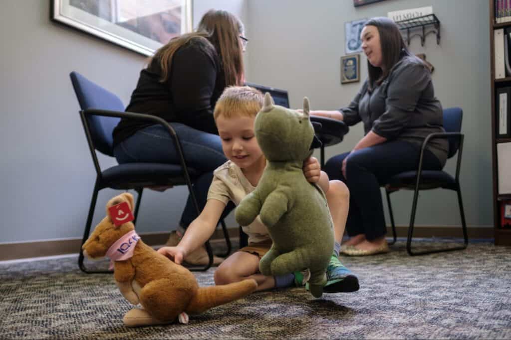 Child playing with stuffed animals in a childcare resource center.