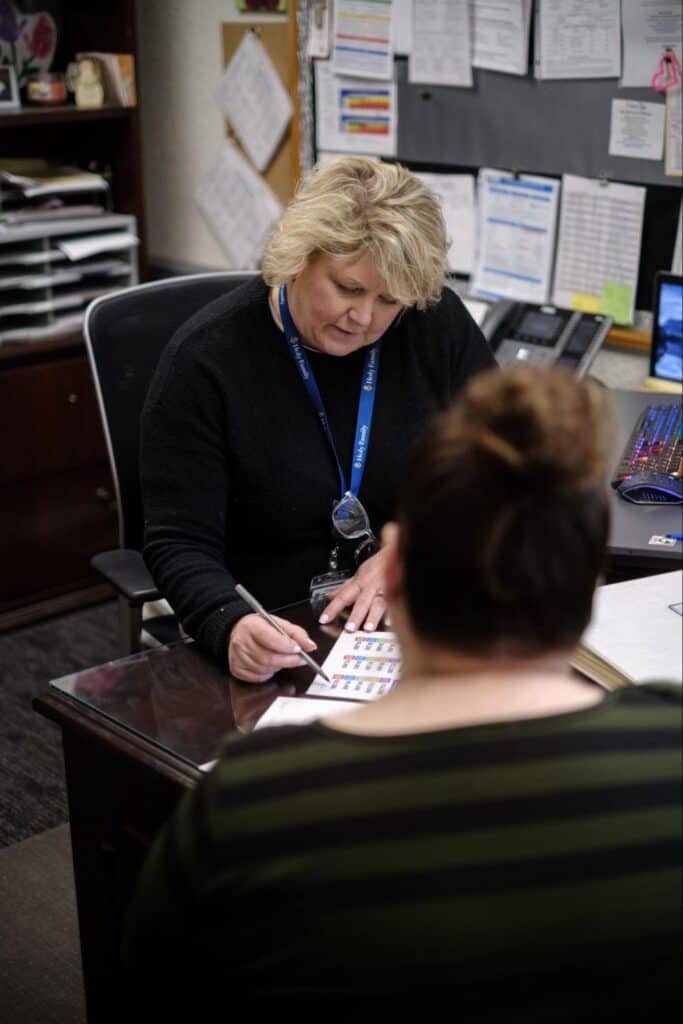 Woman consulting with a parent at an office desk for Iowa Childcare Resource & Referral.