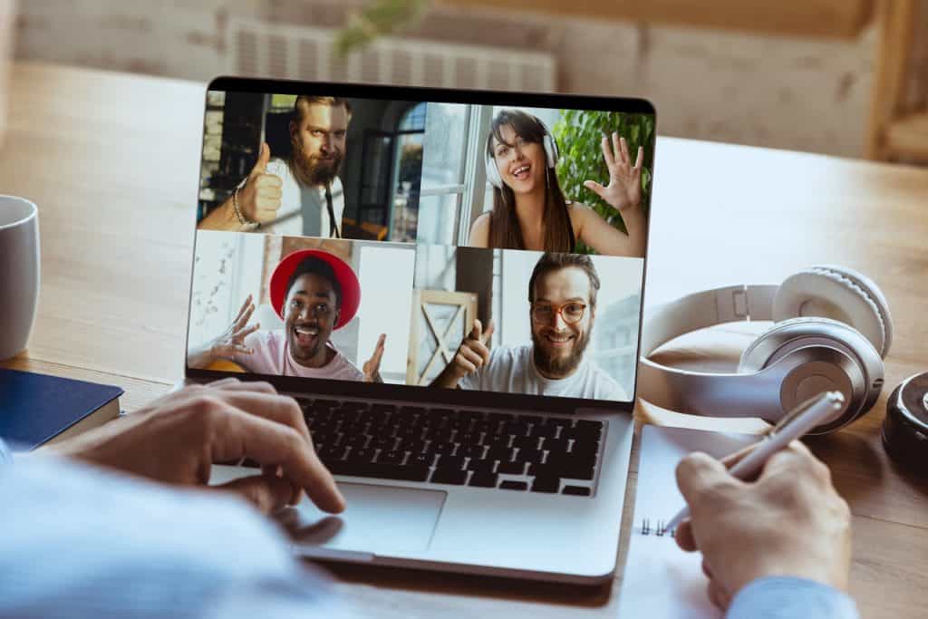 Remote meeting. Man working from home during coronavirus or COVID-19 quarantine, remote office concept. Young boss, manager in front of laptop during online conference with colleagues and team.