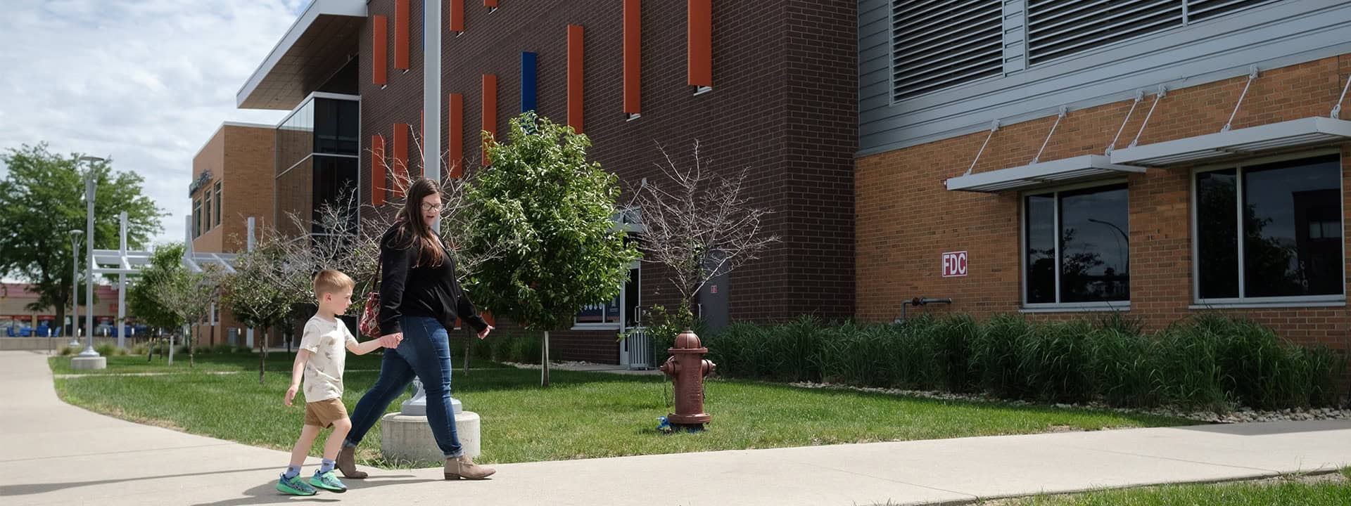 Children walking with adult outside Iowa Childcare Resource & Referral building.