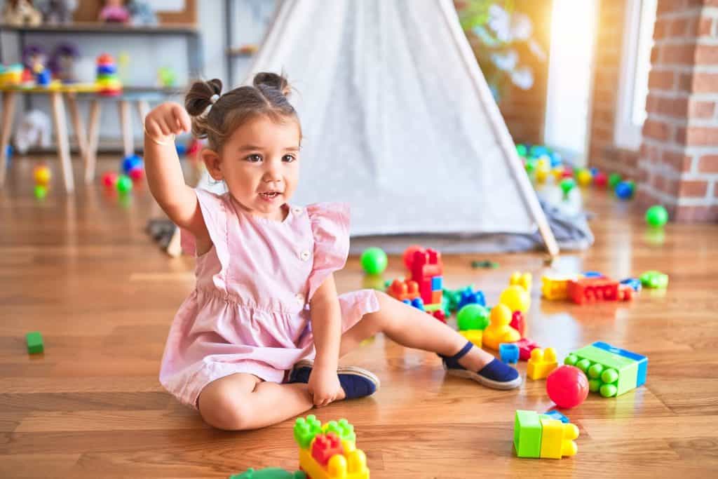 Young girl playing with colorful toys in a childcare setting.