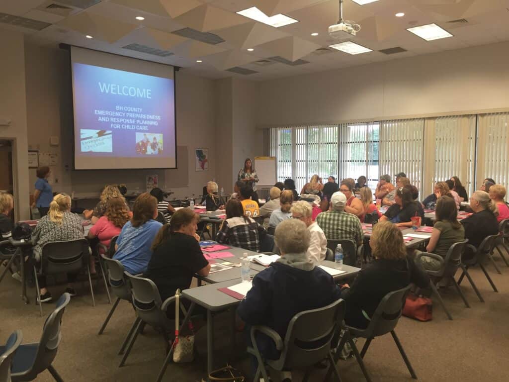 Attendees at Iowa Childcare Resource & Referral event listening to presentation in conference room.
