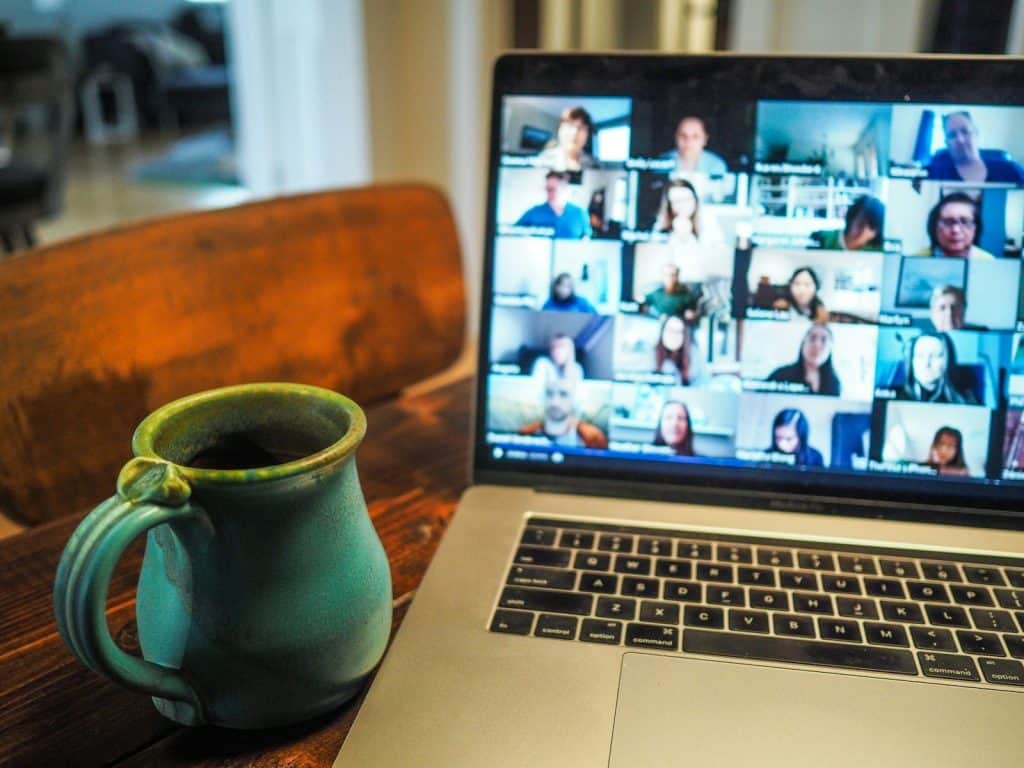 macbook pro displaying group of people in a virtual training